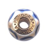 PANDORA - a gold charm. The colourless glass bead with blue swirl patterns, to the gold inner