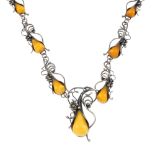 A mid 20th century natural amber necklace. Designed as a central pear-shape natural amber drop