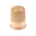 A gold thimble. Of dimpled top with textured edge. Length 1.9cms. Weight 3gms.