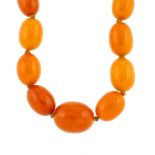 A natural amber bead necklace. The single row of twenty-three graduated oval-shape natural amber