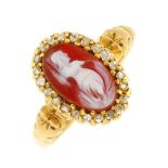 A cameo and diamond ring. The oval-shape shell cameo carved to depict a woman in robes, to the