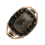 An early 19th century gold memorial ring. Designed as a rectangular glazed woven hair panel, to