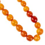 A natural amber bead necklace. Comprising thirty-four roughly spherical beads, measuring