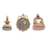 Three fobs. The first a coin set behind a glazed panel to the front and back, one side with