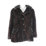 A dark ranch mink three-quarter length jacket. Featuring a notched collar, hook and eye fastenings