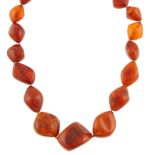 A natural amber necklace. Comprising a single row of graduated baroque shape natural amber beads,