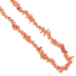 A coral necklace. Designed as polished rough coral pieces. Length 90cms. Weight 26.4gms. This lot