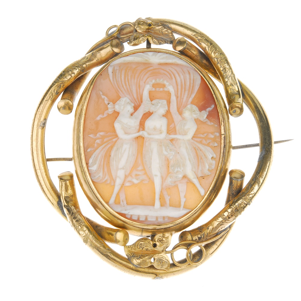 A shell cameo brooch. The central oval-shape shell cameo panel depicting the three graces, to the