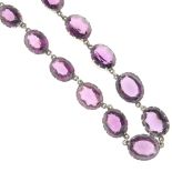 A mid 20th century purple paste necklace. Designed as graduated oval-shape, faceted purple pastes