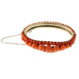 A coral bangle. The hinged bangle set with circular beads set in two rows to the back and in three