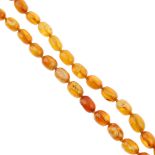 A natural amber bead necklace. The single row of seventy-nine graduated oval-shape beads measuring 1