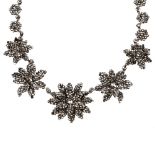 An early 19th century cut steel necklace. Designed as five cut steel flowers, with layered petal