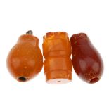 Four carved natural amber nargile mouth piece parts. Three of tapered ovoid shape, one with ivory