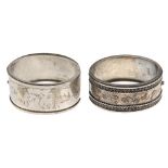 Two late Victorian bangles. The first with applied and engraved, flowers, butterfly and leaf