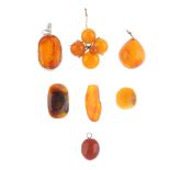 A selection of amber pieces. To include an amber cabochon flower brooch, three amber pendants and