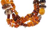 An amber, quartz and plastic bead necklace. Designed as a single cord suspending three rows of