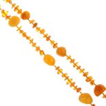 An amber necklace. Designed as a long single row of freeform natural amber pieces, the eight