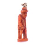 A coral figure pendant. The coral carved into the form of a man walking with a stooped stance,