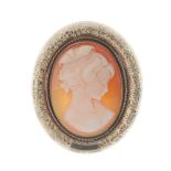 A 9ct gold cameo brooch. Of oval outline, the mount with a D-shape profile, embossed with flowers,