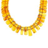 A natural amber necklace and matching bracelet. The necklace designed as graduated amber panels to