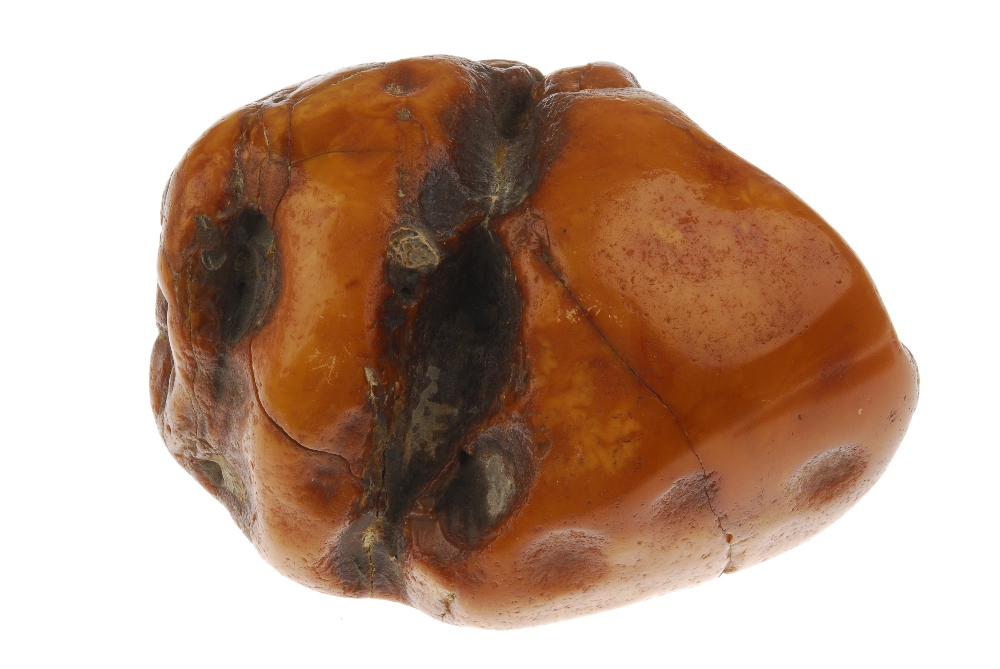 An amber boulder. The boulder of roughly oval shape with visible deep natural pits and fractures. - Image 3 of 4