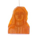 A natural amber carved brooch. Carved into the form of a lady with long hair. Length 5.1cms.