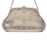 An early 20th century purse. The shaped outline with bow and ribbon design inner border and