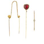 A garnet stickpin, a cased double stickpin and a bar brooch. The garnet in a triangular shape with