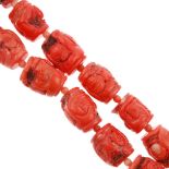 A carved coral bead necklace and bracelet. The necklace comprising a row of barrel-shape carved