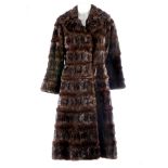 A pieced mink knee length coat. Featuring a notched collar, hook and eye fastenings, with inner