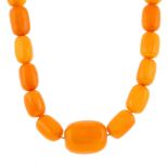 A natural amber bead necklace. Comprising a single row of thirty-five graduated barrel-shape natural