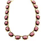 A mid 20th century purple paste necklace. Designed as oval-shape purple pastes claw-set to gold