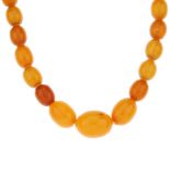 A natural amber necklace. Comprising a single row of forty-eight graduated oval-shape natural