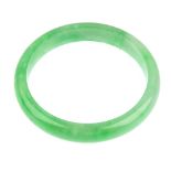 A jade bangle. Designed as a solid circular bangle of D-shape profile. With associated pouch.