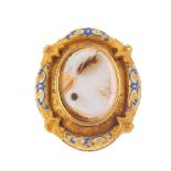 A late Victorian gold enamel cameo brooch. Designed as a central oval cameo depicting a female in