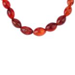 A selection of jewellery. To include a red plastic bead necklace, the oval shape beads to the
