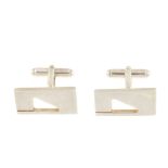 GUCCI - a pair of cufflinks. Designed as rectangles with cut-out triangle shapes, to the hinged