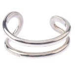 Two items of designer jewellery and a loose charm. The Emporio Armani bangle designed as an open