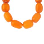 A natural amber bead necklace. Comprising a single row of barrel shape natural amber beads,