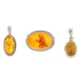 A selection of modified amber jewellery in silver and white metal mounts. To include a violin