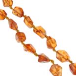 An amber necklace. Comprising a single row of irregularly faceted amber beads, measuring 0.5 to 1.