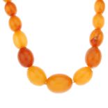 A natural amber necklace. Comprising a single row of fifty-seven oval-shape beads measuring 0.7 to