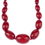 A bakelite necklace. Comprising a single row of forty-six graduated oval-shape beads, measuring 0.