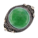 A Chinese jade ring. The circular green jade set to a wirework and beadwork surround. Ring size S.