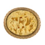 An early 20th century carved ivory brooch. The oval shape ivory panel carved to depict a typical