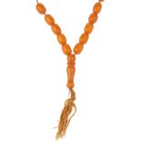 A bakelite prayer bead necklace. The single row of thirty-one barrel-shape beads measuring 1.5 to