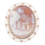 A gold shell cameo brooch. The cameo carved as a village scene with ladies carrying goods on their