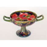 A William Moorcroft twin handled pedestal bowl decorated in the Pomegranate pattern,