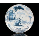 A late 18th Century Delft tin glazed charger decorated with a lady sat upon a branch with her male