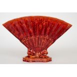 Burmantofts Faience - A red glazed posy vase modelled as a fan with floral decoration to the